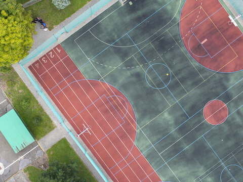 Aerial view of colorful outdoor basketball court with multi sport markings and athletic surface