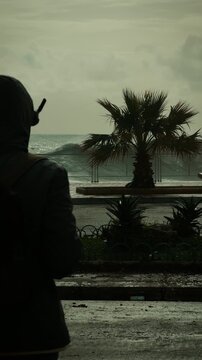 Drone pilot silhouette in front of a high stormy sea wave
