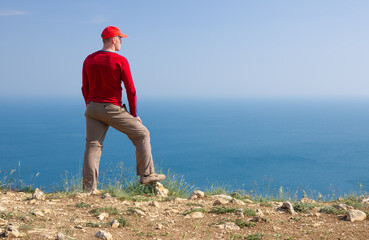 A young man stands on a cliff © Nemeziya