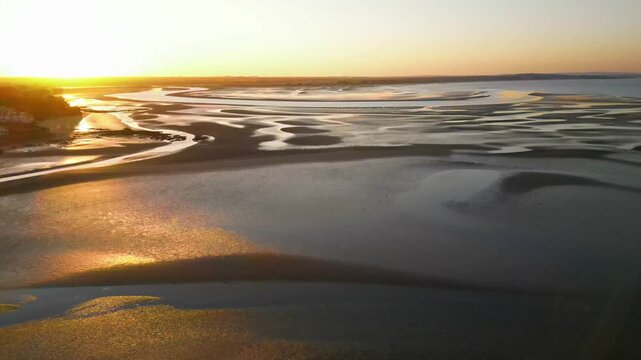 Aerial drone view flying over scenic coastline and beach near Howth at sunset, Ireland
