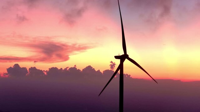 silhouette of wind turbine generator at sunset