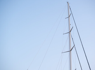 Sailboat mast stands tall against a clear blue sky
