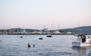 Obraz premium Yachts and boats are moored in a calm harbor at dusk