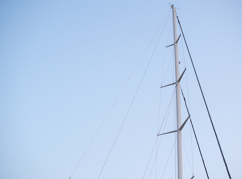 Sailboat mast stands tall against a clear blue sky