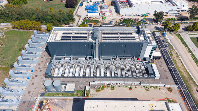 Aerial view of the Equinix Data Center featuring large industrial buildings, rows of cooling units, and technical infrastructure in Castelletto, Lombardia, Italy.