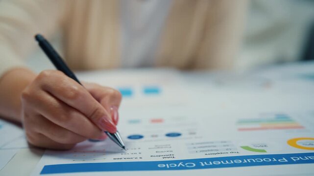 Close up young Asian woman reviews financial documents and writes budget notes at home. Personal finance planning, expense analysis, tax paperwork, household savings, banking strategy, income review.