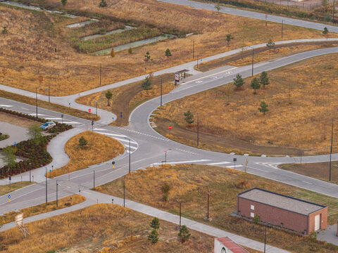 Aerial view of a road intersection with sustainable drainage infrastructure and infiltration basins in a business park in Genk, Vlaanderen, Belgium.