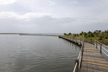 Fototapeta premium Wooden boardwalk spanning across tranquil alqueva lake in alentejo