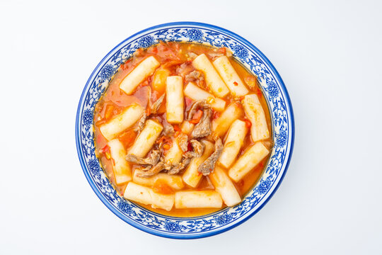 A plate of stir-fried rice cakes with beef and tomato