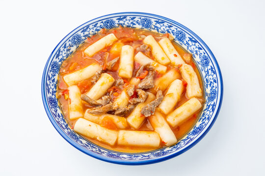 A plate of stir-fried rice cakes with beef and tomato