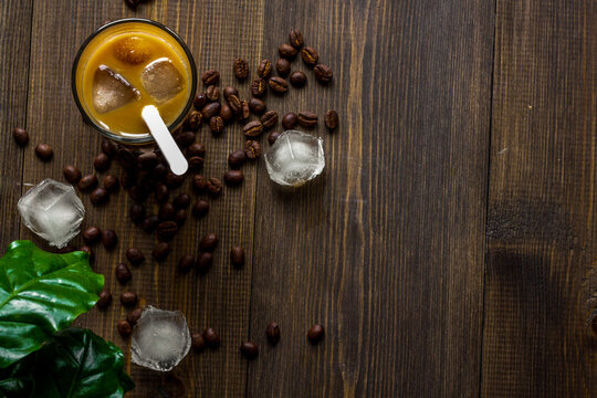 coffee with ice in glass on wooden background top view