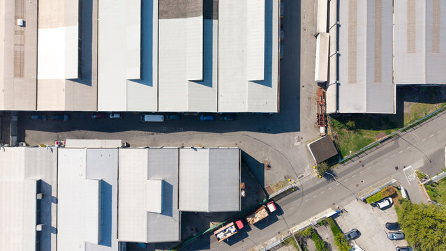 Aerial view of the industrial facility of a leading cosmetics packaging manufacturer, featuring metal rooftops, a parking area, and infrastructure in San Giuliano Milanese, Lombardy, Italy.