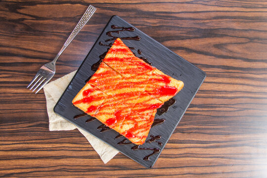Slice of dessert on a plate with toppings served at a cafe in the afternoon