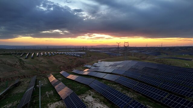 solar power plant at sunset with panels on hillside