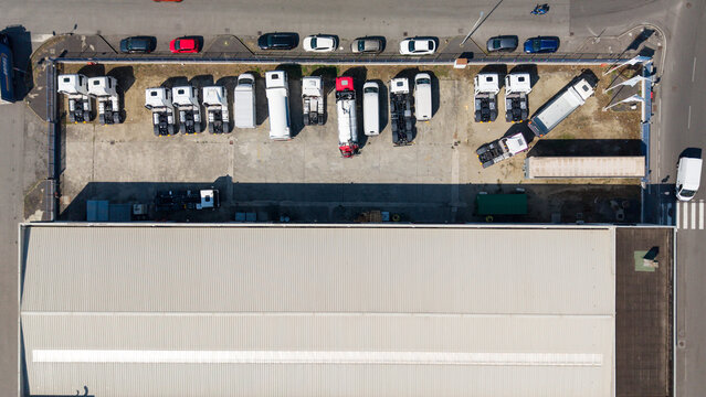 Aerial view of a fleet of MAN trucks parked in an industrial area in Area Industriale, Lombardia, Italy.
