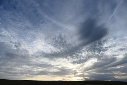 Ciel nuageux avec une grande ombre en forme d'ange ou d'oiseau , ou de cornes sombres . M&eacute;t&eacute;o tr&egrave;s changeante et perturb&eacute;e un soir de septembre en Lorraine