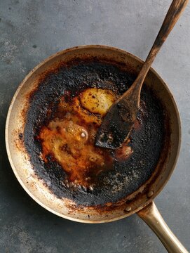 Top view of a burnt cooking pan before cleaning, stubborn kitchen mess and household cleaning concept