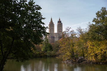 Autumn lake landscape in Central Park with Manhattan residential towers framed by trees © Natali
