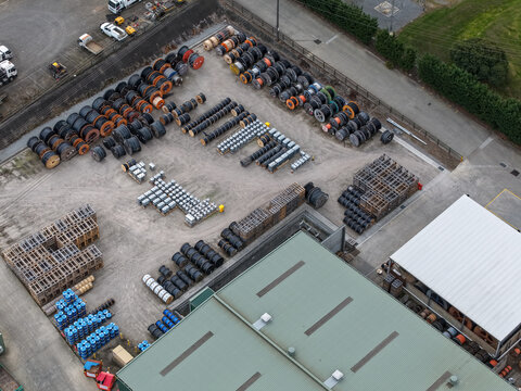 Aerial view of the Mondo Power industrial facility featuring rows of large cable reels, storage crates, and a warehouse building in Ringwood, Victoria, Australia.