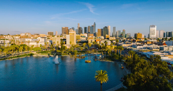 Aerial view of Echo Park Lake with its iconic fountain and lush palm trees set against the modern Los Angeles skyline in Los Angeles, California, United States.