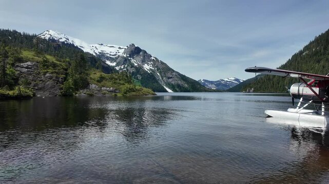 Steady round level wide footage of a lake with a seaplane float parked on the shoreline, Nooya Lake, Alaska 