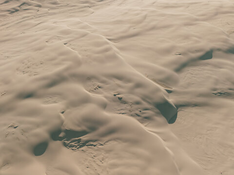 Aerial view of the vast sand dunes at Birubi Point with undulating patterns and soft shadows in the late afternoon light in Anna Bay, New South Wales, Australia.