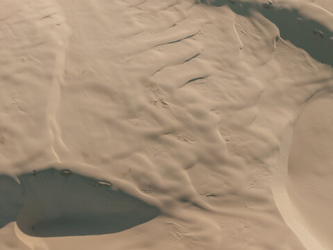 Aerial view of Birubi Point sand dunes with undulating patterns and soft shadows in the desert landscape of Anna Bay, New South Wales, Australia.