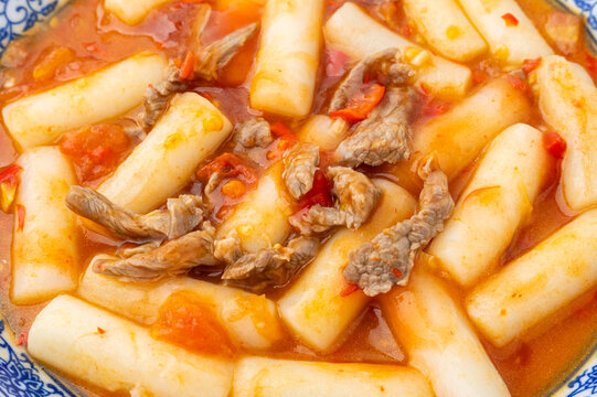 A plate of stir-fried rice cakes with beef and tomato