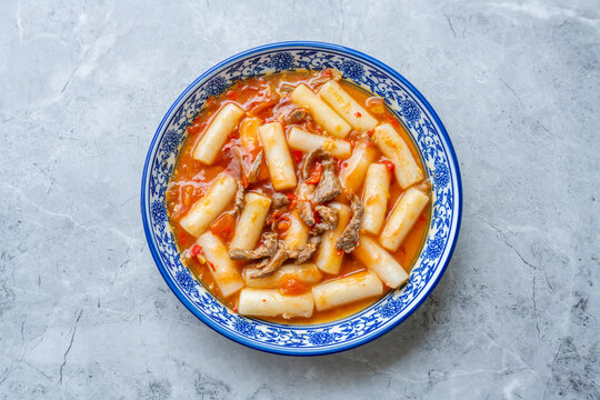 A plate of stir-fried rice cakes with beef and tomato