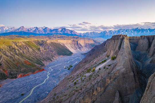 Aerial drone view of a deep gorge with a winding river and cliffs at sunset in Anjihai Grand Canyon, Xinjiang, China