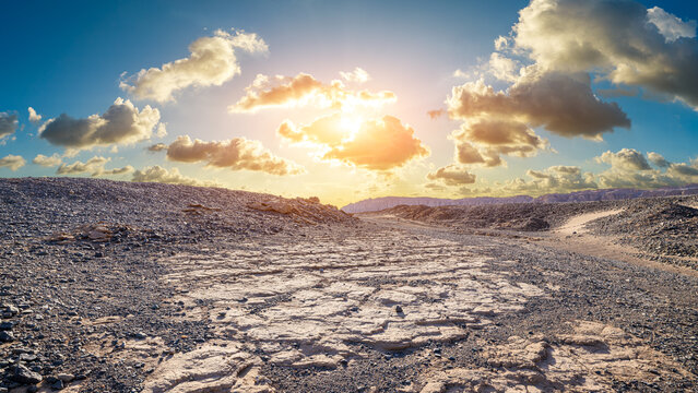 Breathtaking sunset casting warm light over a barren desert terrain in Dahaidao, Xinjiang, China