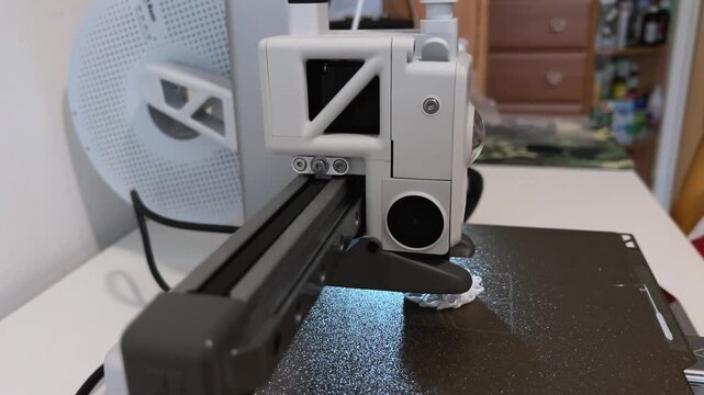 Close-up video of a mini 3D printer operating, printing at home