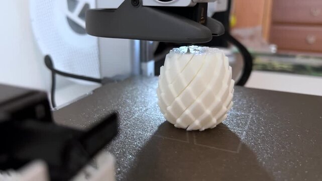 Close-up video of a mini 3D printer operating, printing at home