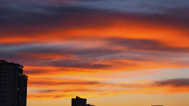 Panoramic urban view of Rijeka, Croatia, at sunset, with residential high-rise buildings silhouetted against the dramatic Kvarner Bay landscape and distant mountains