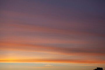 Fototapeta premium Sunset over the horizon with colorful clouds and light fading in the sky