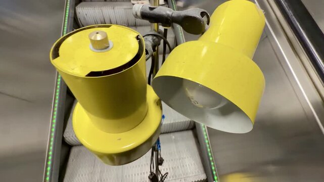 Yellow Retro Floor Lamp Riding a Metro Escalator