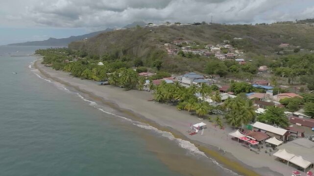 drone flying at the edge of the ocean plague du coin in martinique, france, in the region of le carbet overlooking the marina n some boats overlookin in land the hospital the volcano n part of the cit