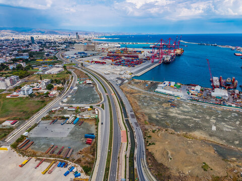 Aerial view of the Limassol Port container terminal with cargo ships, cranes, and shipping containers along the coastline in Lemesos, Lemesos, Cyprus.