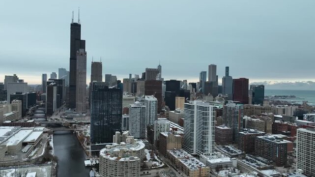 Aerial shot establishing the Chicago River and downtown skyscrapers in snow