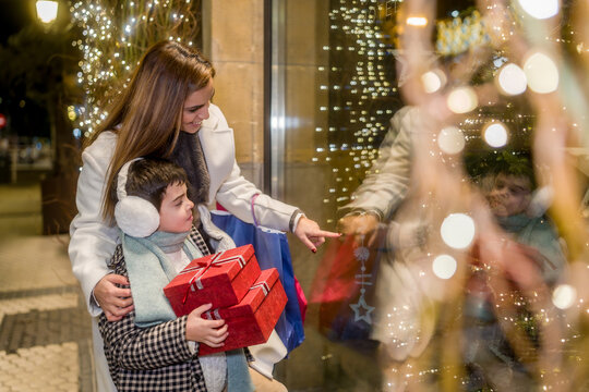 Mother and child enjoying christmas shopping together at night