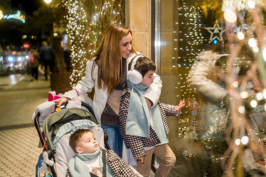 Mother and children enjoying christmas shopping window display