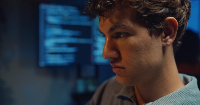 Closeup young adult male freelance developer typing write prompt AI bot app program nomad terminal coding at office night. Artificial intelligence dashboard, robotics user interface, machine learning.