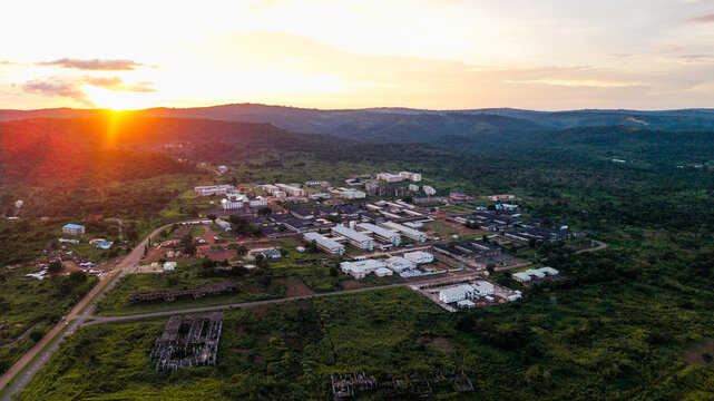 Aerial view of the University of Nigeria Teaching Hospital surrounded by lush green hills and vegetation at sunset in Enugu, Enugu, Nigeria.