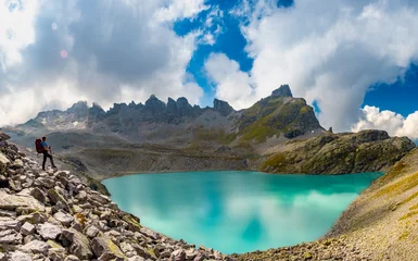 Female hiker with backpack enjoying epic view of Wildsee lake on Pizol mountain range in Switzerland. Travel sport wanderlust concept. © Kotangens