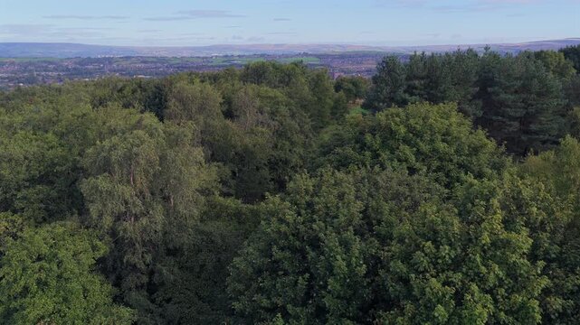 Aerial video reveal  of Oldham Edge Woodland Pathway and Pennine Horizon in Greater Manchester. 