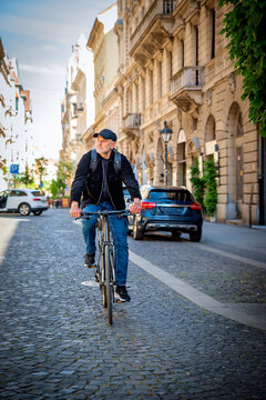 A middle-aged man riding a bicycle in a European city