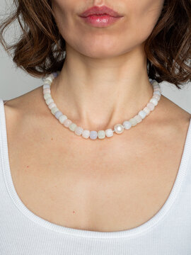 Fashion portrait of woman wearing gemstone jewelry necklace - warm neutral aesthetic with natural beauty style
