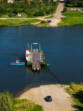Aerial view of the Vilkija ferry crossing on the Nemunas River, with a ferry boat docked at the riverbank and a car waiting to board, Vilkija, Kaunas County, Lithuania.