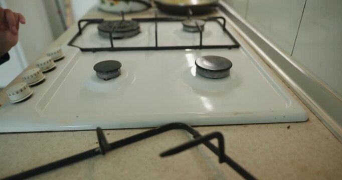 Close-up children's hands wash gas stove kitchen. 4K 10-bit