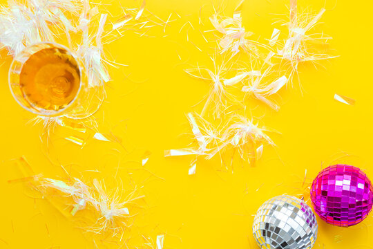Disco balls with confetti and glass of wine, top view. Party time concept.